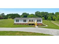 Charming single-story home featuring fresh exterior paint, and a cute wooden deck at 5606 S Rocky River Rd, Monroe, NC 28112