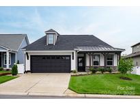 Charming home with a black garage door, covered front porch, and well-maintained lawn at 602 Compass Dr, Denver, NC 28037