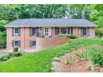 Charming brick home featuring a well-manicured lawn and inviting front entrance at 6626 Rocky Falls Rd, Charlotte, NC 28211