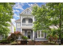 Charming two-story home with a covered front porch and manicured landscaping at 7043 Blakeney Greens Blvd, Charlotte, NC 28277