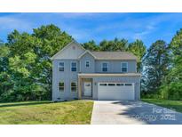 Charming two-story home with a light blue exterior, attached two-car garage, and well-maintained lawn at 7874 Lucky Creek Ln, Denver, NC 28037