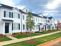 Row of new townhomes with black shutters, landscaping, sidewalks, and fresh green lawn at 8122 Jacey Ln # 19, Huntersville, NC 28078