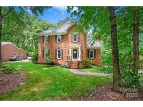 Charming brick home featuring a manicured lawn, black shutters, and a welcoming front entrance at 8217 Lansford Rd, Charlotte, NC 28277