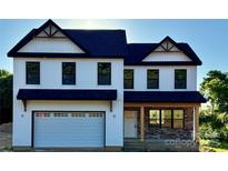 Charming two-story home with a two car garage, stone accents, and a welcoming front porch at 1308 Austin Chaney Rd, Wingate, NC 28174