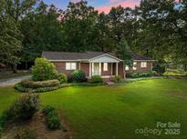 Charming brick home with a well-maintained front lawn and mature trees at 14415 Old Beatty Ford Rd, Gold Hill, NC 28071
