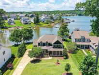 Stunning lakefront home with mature trees, lush lawn and private dock; perfect for relaxing and entertaining at 164 Twin Sisters Ln, Mooresville, NC 28117