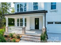 Charming front porch with brick accents, white columns, and a cozy seating area at 236 Wheatfield Dr # 102P, Statesville, NC 28677