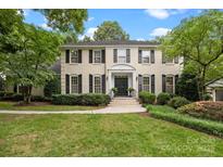 Elegant, two-story home with a classic painted brick facade, black shutters, and professionally landscaped front yard at 2709 Wamath Dr, Charlotte, NC 28210