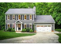 Traditional two-story home with gray siding, black shutters, a two-car garage, and well-manicured lawn at 3314 Mara Ct, Matthews, NC 28105