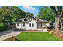 Charming exterior of a white two-story home with a well-manicured lawn and beautiful landscaping at 343 Melbourne Ct, Charlotte, NC 28209