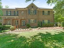 Charming brick home boasts mature landscaping, a covered porch, and stylish shutters at 4026 Barclay Downs Dr, Charlotte, NC 28209