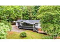 Charming single-story home with a metal roof, front deck, and wooded surroundings at 51 Emily Ln, Taylorsville, NC 28681
