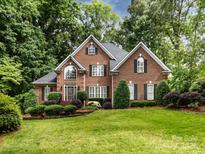 Charming two-story brick home featuring a well-manicured lawn, lush landscaping, and classic architectural details at 5816 Valley Stream Trl, Waxhaw, NC 28173