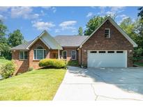 Charming two-story brick home with a well-manicured lawn and a spacious driveway leading to a two-car garage at 7545 Rabbit Cir, Denver, NC 28037