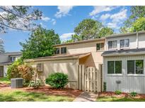 Charming townhome featuring a fenced entryway, lush landscaping, and a well-maintained lawn at 7928 Horse Chestnut Ln, Charlotte, NC 28277