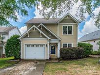 Charming two-story home featuring a one car garage and a welcoming front door with lovely landscaping at 10639 Secret Garden Ln, Charlotte, NC 28214