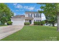 Charming two-story home featuring a well-manicured lawn, attached garage and classic shutters on a sunny day at 1111 Balcorn Pl, Charlotte, NC 28214