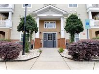 Inviting condo entrance featuring brick accents, manicured landscaping and visible unit addresses at 11867 Ridgeway Park Dr, Charlotte, NC 28277