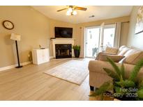 Inviting living room featuring a fireplace, neutral tones, and access to outdoor space at 11867 Ridgeway Park Dr, Charlotte, NC 28277