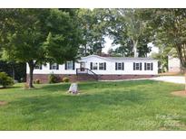 Inviting home with manicured front yard, brick foundation, complemented by mature trees at 14335 Saint Johns Dr # 83, Stanfield, NC 28163