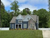 Beautiful two-story home with a combination of blue siding and stone facade, complemented by a well-manicured lawn at 1622 Hunters Place Rd, York, SC 29745