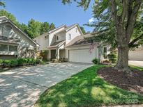 Charming home showcasing a manicured lawn, driveway, and two-car garage with lovely trees in a vibrant neighborhood at 17732 Kings Point Dr, Cornelius, NC 28031