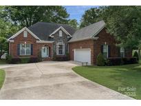Charming brick home with manicured lawn, arched entryway, and a spacious driveway to a two car garage at 18118 Pompano Pl, Cornelius, NC 28031