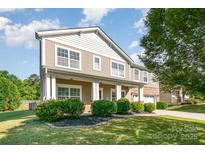 Charming two-story home featuring a welcoming porch, manicured lawn, and tasteful landscaping at 1905 Yellow Daisy Dr, Matthews, NC 28104