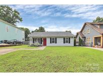 Charming single-story home with a manicured lawn, red front door, and classic black shutters at 2117 Yadkin Ave, Charlotte, NC 28205