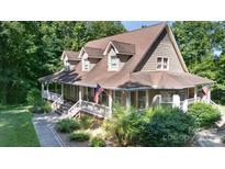 Charming two-story home featuring a welcoming front porch, American flag, and beautifully landscaped yard at 2168 Sunset Cir, Fort Mill, SC 29715