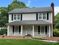 Charming two-story home featuring a welcoming front porch, black shutters, and a well-maintained lawn at 2507 Birnen Dr, Charlotte, NC 28210