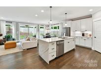 Modern kitchen with a large waterfall island, stainless steel appliances, and an open floor plan concept at 2517 Marlowe Ave, Charlotte, NC 28208
