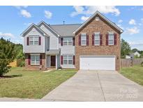 Charming two-story home featuring a brick facade, attached two-car garage, and well-maintained front yard at 2809 Waycross Dr, Monroe, NC 28110