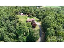 Expansive aerial view showcasing a home with a barn and long driveway nestled among lush greenery and mature trees at 3151 Lynn Mountain Rd, Vale, NC 28168