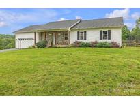 Inviting ranch home with stone accents, attached garage, and well-manicured lawn on a lush, green lot at 350 Moose Dr, Stony Point, NC 28678