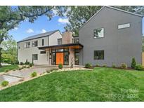 Modern two-story home showcasing a manicured lawn and a striking orange front door at 3822 Topsfield Rd, Charlotte, NC 28211