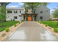 Modern home featuring manicured landscaping, a concrete driveway, and a striking orange front door at 3822 Topsfield Rd, Charlotte, NC 28211