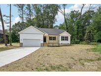 Charming home featuring a white exterior, front porch, and attached two-car garage at 403 W Charlotte Ave, Mount Holly, NC 28120