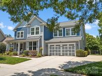 Charming two-story home with a manicured lawn, two-car garage, and a welcoming blue and gray color scheme at 5005 Hedgebrook Ln, Waxhaw, NC 28173