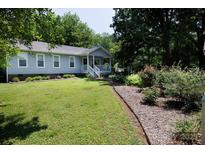 Charming home with a well-maintained front lawn, complemented by beautiful flowerbeds and mature trees at 517 Powell St, Rock Hill, SC 29732