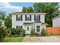 Charming two-story home with white siding, black shutters, and a lovely landscaped front yard at 719 Dawn Cir, Charlotte, NC 28213