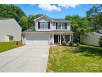 Charming two-story home featuring a well-manicured front yard and attached two-car garage at 820 Settlement St, Clover, SC 29710