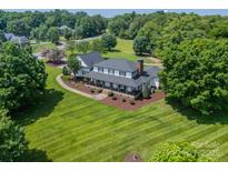 Beautiful home with a well-manicured lawn and mature trees creating an inviting and picturesque setting at 8698 Rocky River Rd, Harrisburg, NC 28075