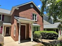 Charming brick townhouse featuring a covered entryway and well-maintained landscaping at 9404 S Vicksburg Park Ct, Charlotte, NC 28210