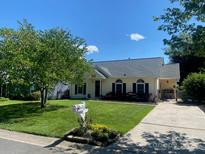 Charming single-story home featuring a well-manicured lawn and inviting curb appeal at 9612 Farmridge Ln, Matthews, NC 28105