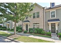Charming brick townhome with a well-manicured lawn and lush landscaping at 1329 Jacemans Way, Cornelius, NC 28031