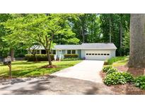 Charming single-story home with a well-manicured lawn, mature trees, and an attached two-car garage at 144 Stoneybrook Rd, Salisbury, NC 28147