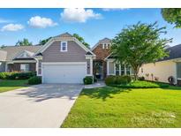 Charming home with a two-car garage, stone accents, and a well-manicured lawn at 1974 Links View Dr, Fort Mill, SC 29707