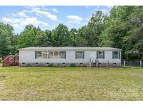 Traditional single-story home with white siding, complemented by a well-maintained green lawn and surrounding trees at 3585 Woodstream Dr, Maiden, NC 28650