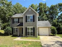 Charming two-story home featuring a one-car garage and manicured lawn surrounded by mature trees at 4240 Ladys Slipper Ln, Matthews, NC 28105